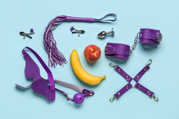 Different sex toys and tasty fruits on blue background