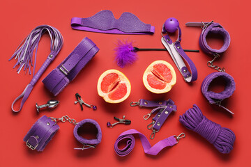 Different sex toys and tasty grapefruit on red background