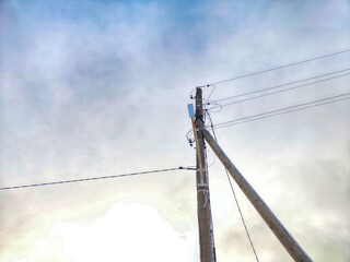 Old pole with wires against the sky. Electric transmission line. Eco-friendly energy