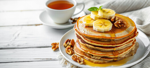 healthy gluten free banana oatmeal pancakes with banana, walnuts and maple syrup on a white wooden table - Powered by Adobe