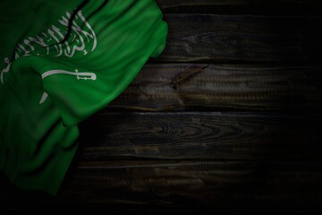 nice any celebration flag 3d illustration. - dark image of Saudi Arabia flag with large folds on old wood with free place for your content