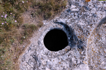 The ancient cave city of Bakla, outside view. Round grain pits for grain storage.