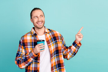 Portrait of positive guy wear flannel shirt indicating look at discount empty space hold coffee...