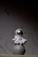 Plastic toy figure astronaut on moon concrete background Copy space. Concept of out of earth...