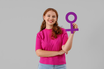 Young woman with gender symbol on light background