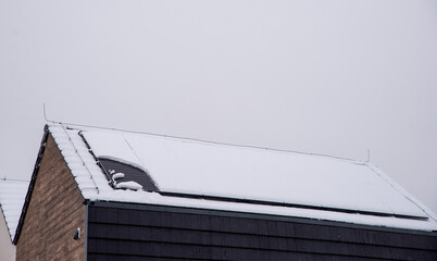 Roof of a house with solar panels covered with snow