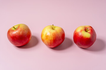Juicy apples on a pink background