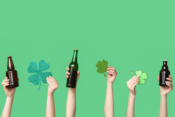 Hands with beer and clover on green background. St. Patrick's Day celebration