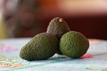 Three fresh avocados on the kitchen table.