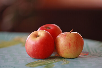 Three fresh apples on the kitchen table.