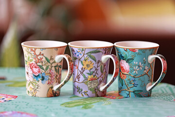 Three beautiful ceramic cups with flowers.