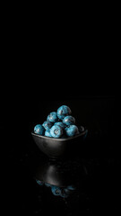 Blueberries and blueberries in a bowl on a black background