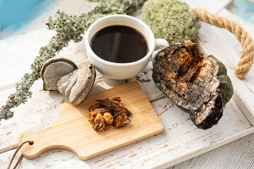 Mushroom coffee chaga superfood. Dried mushrooms and and a cup of coffee. Healthy organic energizing adaptogen, endurance boosting food trends.
