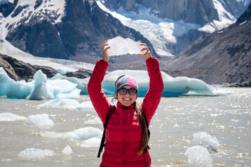Mujer alzando bloque de hielo en la Laguna Torre, en señal de triunfo por haber llegado allí. El...