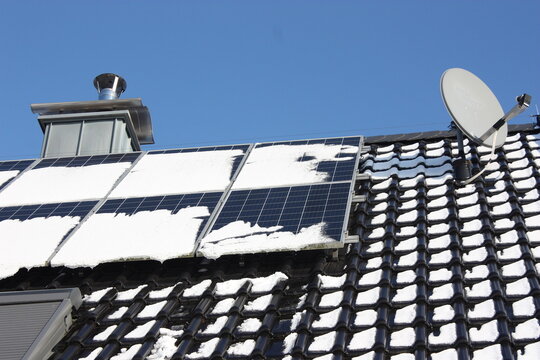 Ineffizienz einer schneebedeckten Photovoltaikanlage bei blauem Himmel