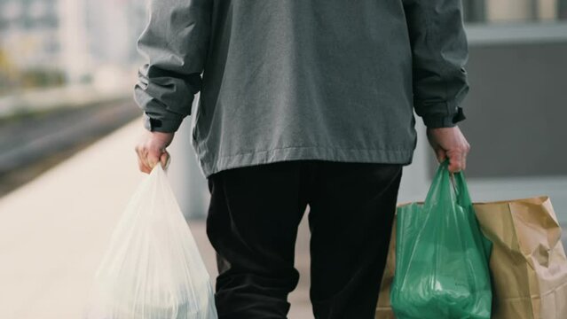 Back View of Man Carrying Grocery Bags in Daily Commute