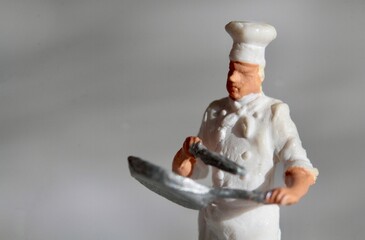 miniature figurine of a chef with a fork preparing some food