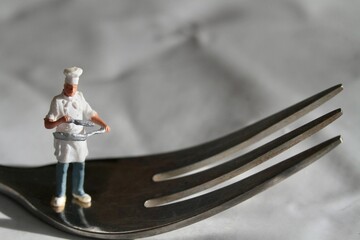 miniature figurine of a chef with a fork preparing some food