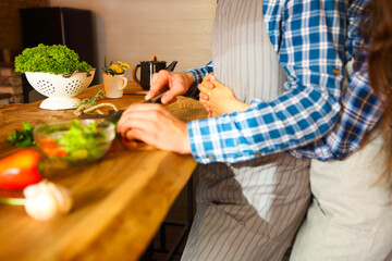 Young man and woman cooking together at kitchen