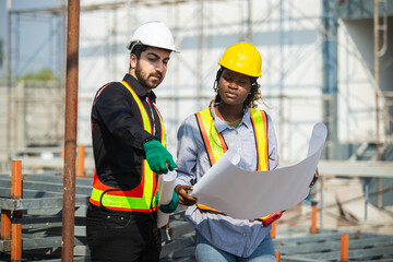Construction civil engineer man and woman African American checking quality of work in construction...