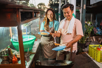 indonesian female helping male seller cooking fried rice