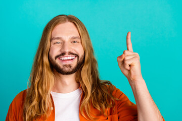 Closeup photo of young cheerful clever blond man wearing orange shirt point forefinger up found idea plan isolated on cyan color background