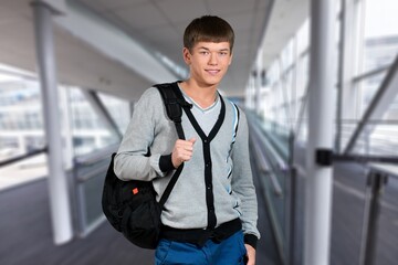 Obraz premium College student man walking at university holding backpack