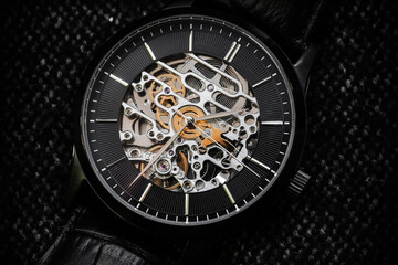 Black clock face with metal details of mechanic skeleton watch - obrazy, fototapety, plakaty