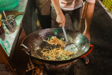 cropped view of asian man cooking noodle using wok