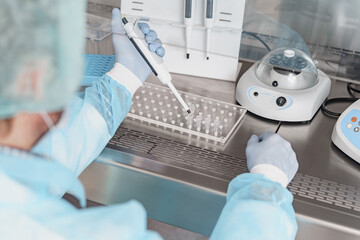 Back view of scientist is using micropipette for biochemical test analysis in medical laboratory