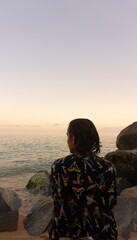 woman looking at the sunset over the ocean.lateral view.Vertical