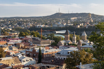 View of the Avlabari district - the old part of Tbilisi. Sights of Tbilisi: Rike Park, cultural center, presidential palace, Trinity Cathedral.  Hills on the horizon.