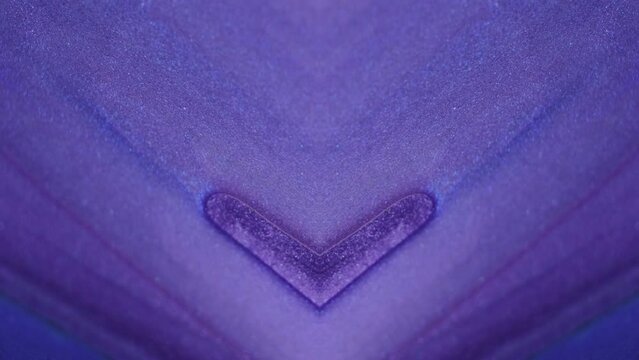 Glitter ink flow. Geometric kaleidoscope. Defocused purple blue color shimmering texture paint spill motion diamond heart shape symmetrical ornament abstract art background.