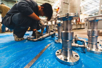 A man starts using a weld hardness the stainless steel piping flange valve component