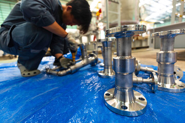 A man starts using a weld hardness the stainless steel piping flange valve component