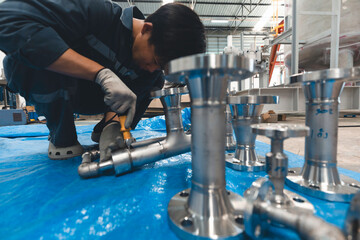 A man starts using a weld hardness the stainless steel piping flange valve component