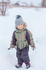 Fototapeta na wymiar Little boy joyful playing in the snow