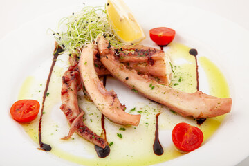 Gourmet tasty octopus with lemon and cherry tomatoes