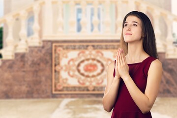 Portrait of young female praying to God for blessing