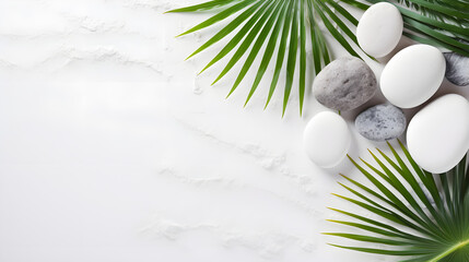 White background with sea stones and palm branch, top view - obrazy, fototapety, plakaty