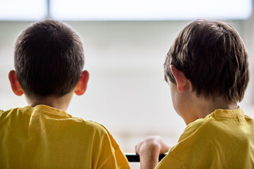 Deux garçons en jaune observant un spectacle