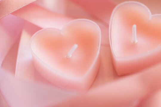 candles tablets in shape of heart on background of pink ribbons. valentine's day.