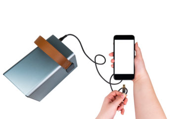 A smartphone with a blank transparent screen in one hand and a USB cable connected to a large power bank (charging station) in the other hand on a transparent background. Mobile power supply