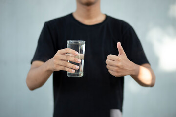 Close up of a man hands holding a water glass with tumbs up