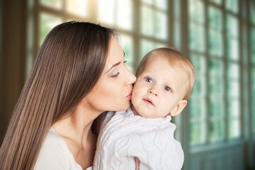 portrait of beautiful mother kissing her child