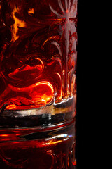 Classic Negroni Cocktail in a retro glass with ice and orange peel on a black background.Closeup.Selective focus.