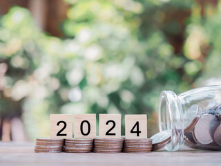 Wooden block with number 2024 on stack of coins. The concept of saving money, Financial, Investment...