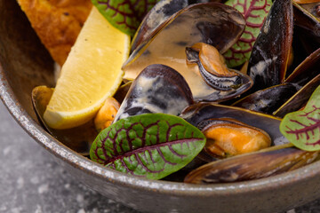 Mussels in a plate, with chilli pepper shot from the top with lemon and toasted bread.Closeup.Selective focus