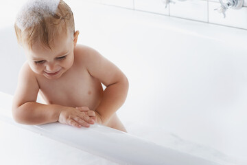 Happy baby in bath with soap, bubbles and cleaning on mockup in morning routine for hygiene,...