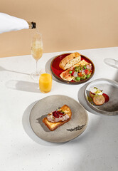 Elegant brunch spread with omelet, pate on brioche toast, and syrniki, served with sparkling wine and orange juice